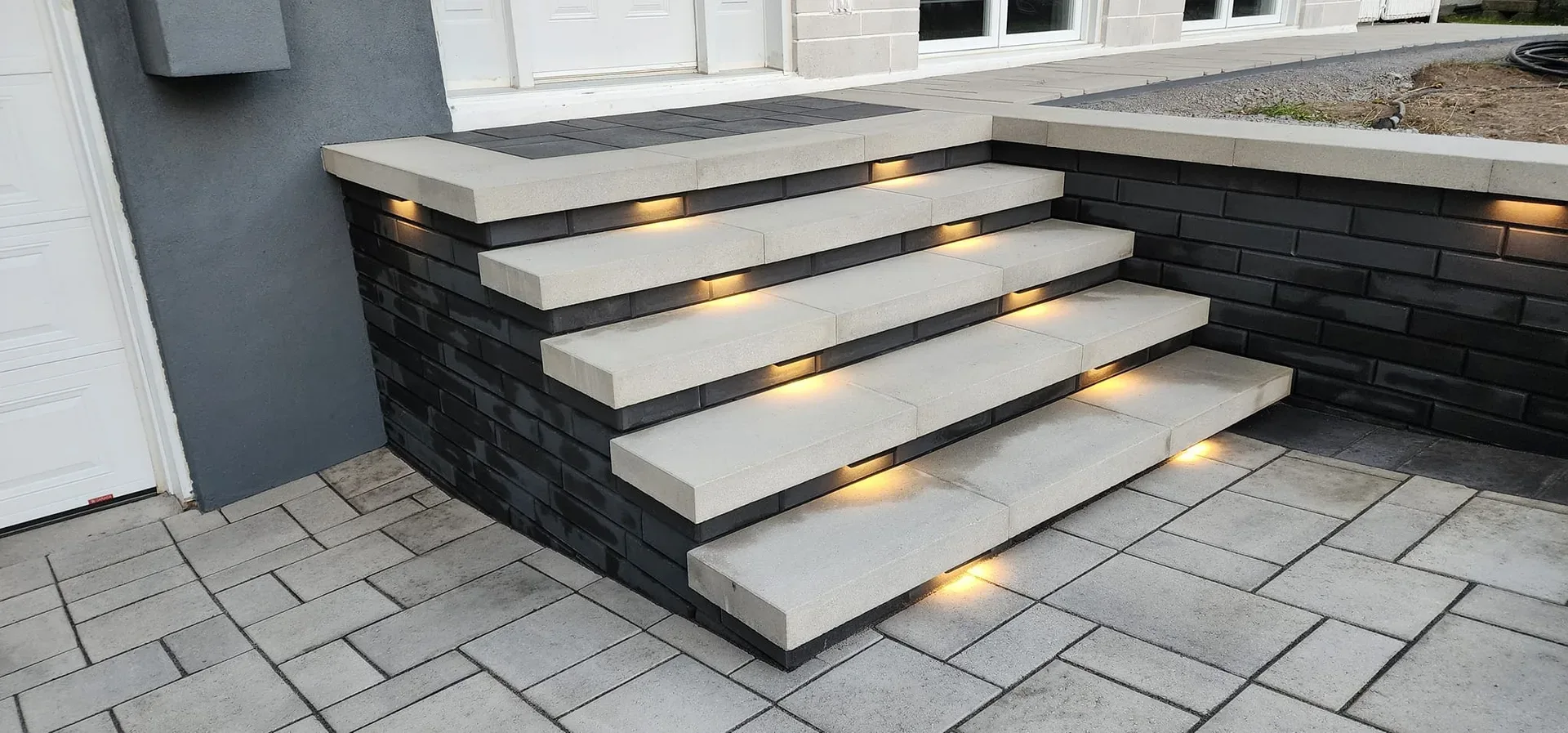 Illuminated entrance steps with dark masonry sides
