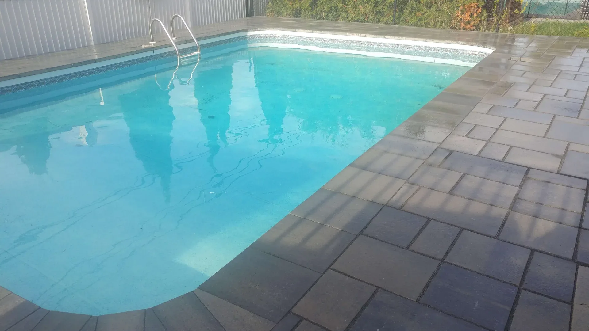 Grey interlocking paving around a swimming pool